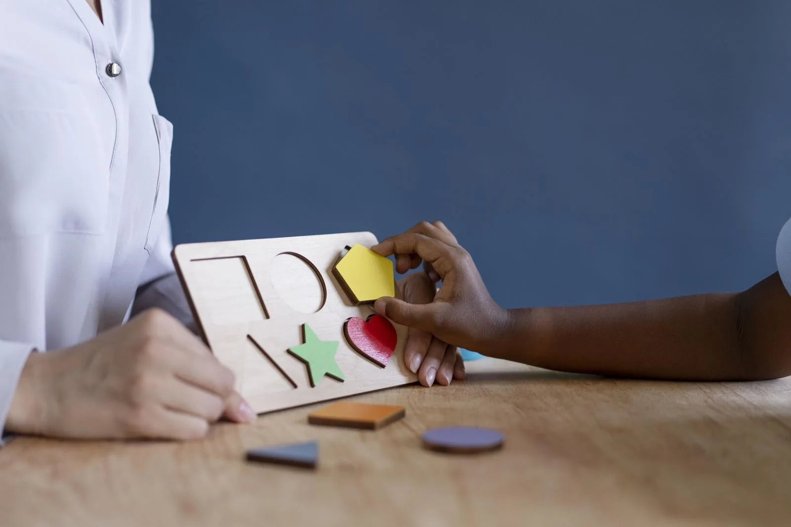 Criança em sessão de terapia multidisciplinar com profissional de saúde, ilustrando tratamento de transtorno do espectro autista